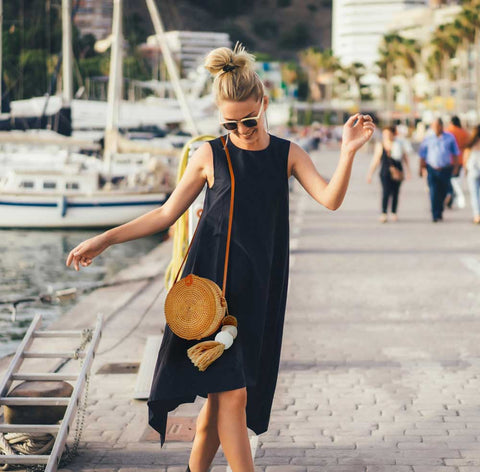girl wearing straw bag on a seaside city